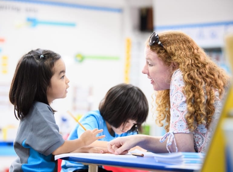Teacher discussing something with young student at Nexus International School Singapore