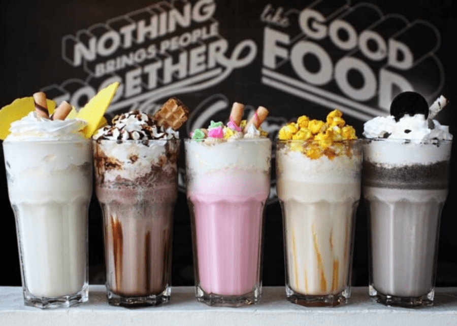 five milkshakes against a black wall