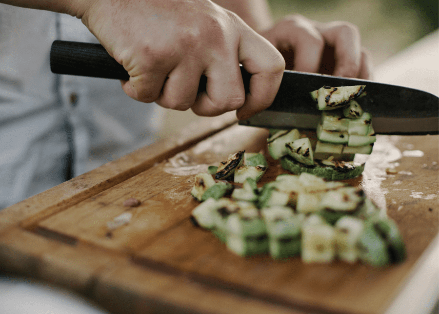 person chopping vegetables with a knife domestic helper courses